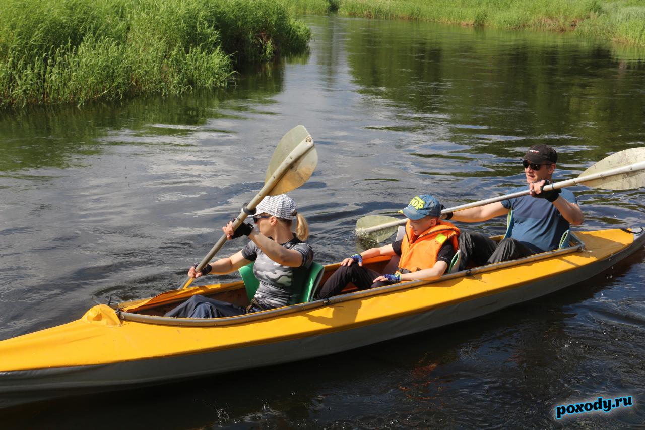 Дети участвуют в походе на байдарках вместе с родителями