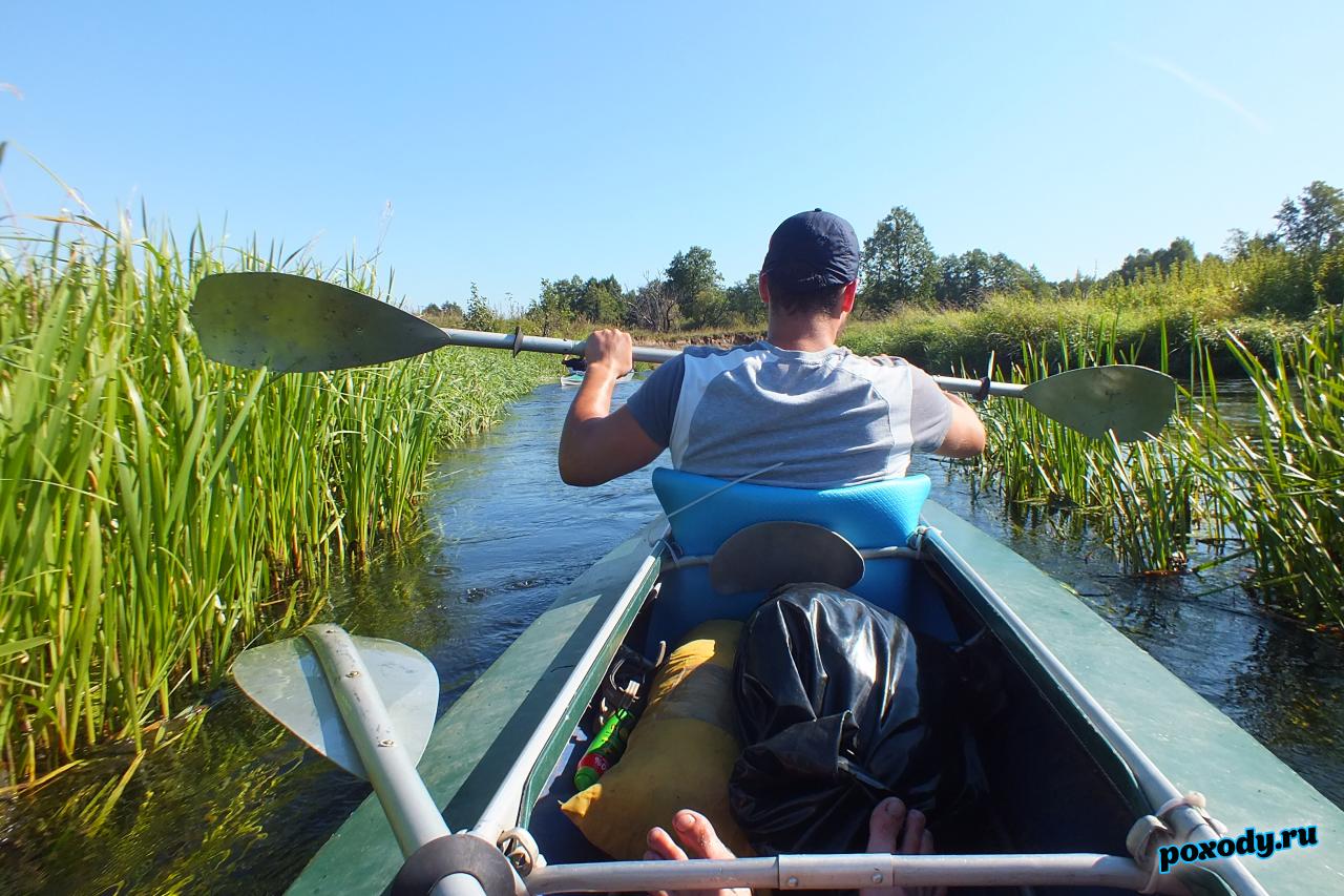 Байдарка на сплаве по реке среди камыша